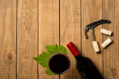 Bir şişe şarap ve şarap ahşap arka plan üzerinde cam. Kopya alanı ile üstten görünüm.