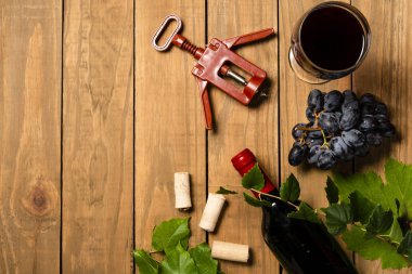 Bir şişe şarap avuç üzüm ve Mantar tıpa ahşap arka plan üzerinde. Kopya alanı ile üstten görünüm.