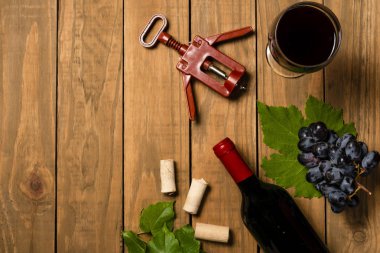 Bir şişe şarap avuç üzüm ve Mantar tıpa ahşap arka plan üzerinde. Kopya alanı ile üstten görünüm.