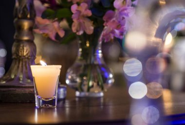 Mum ve kenarındaki olay dekorasyon çiçek dolu vazolar.