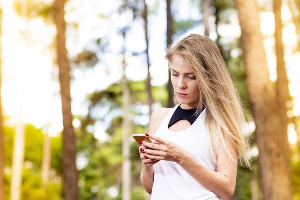 Hermosa Modelo Rubia Con Ropa Gimnasio Utilizando Teléfono Celular Fondo — Foto de Stock