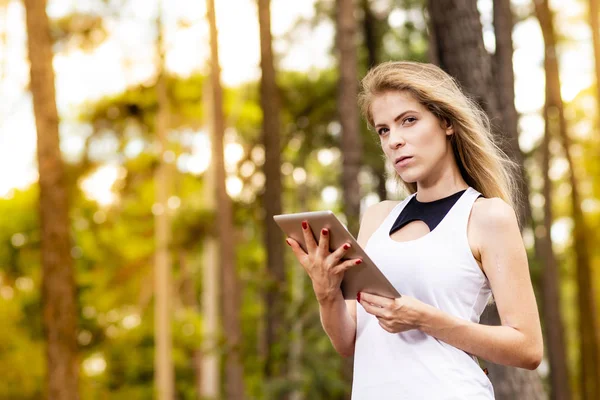 Hermoso Modelo Usando Tableta Fondo Bosque Borroso Con Luz Del — Foto de Stock