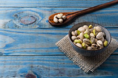 Seramik kap içinde mavi çam ahşap kavrulmuş fıstık.