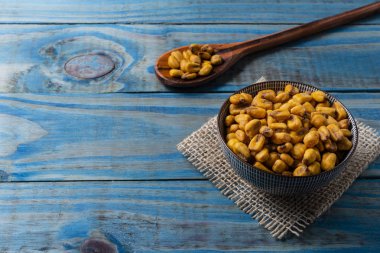 Hardal ve mavi çam üzerinde seramik tencere içinde ballı kızarmış Mısır.