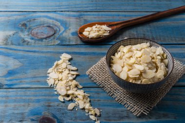 Mavi çam üzerinde seramik tencere içinde lamine badem.