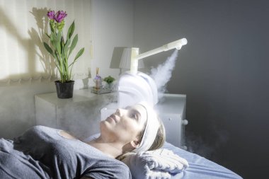 Güzellik merkezinde ozon yüz buharlı ile yüz güzellik bakımı. Beaultiful Sarışın Kız.
