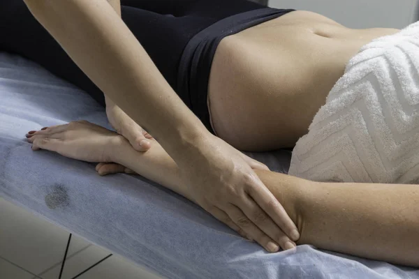 Beautiful blond woman receiving Shiatsu Treatment from a therapist.