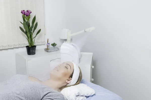 Güzellik merkezinde ozon yüz buharlı ile yüz güzellik bakımı. Beaultiful Sarışın Kız.
