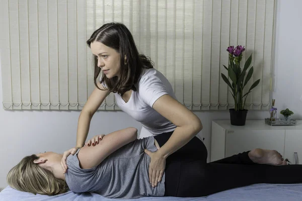 Blond Woman having chiropractic adjustment. Osteopathy, Alternative medicine, pain relief concept. Physiotherapy, sport injury rehabilitation.