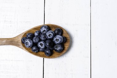 Tahta arka planda taze yaban mersinli ahşap kaşık..