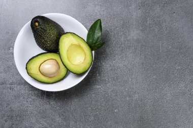 Dokulu gri arka plan üzerinde seramik tencere içinde Avokado.