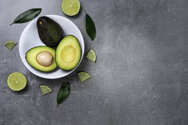 Dokulu gri arka plan üzerinde seramik tencere içinde Avokado.