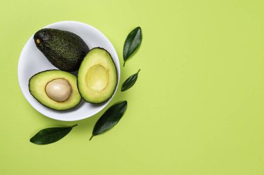 Yeşil arka plan üzerinde seramik tencere içinde Avokado.
