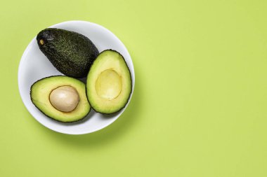 Yeşil arka plan üzerinde seramik tencere içinde Avokado.