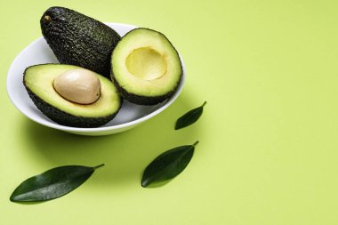 Yeşil arka plan üzerinde seramik tencere içinde Avokado.
