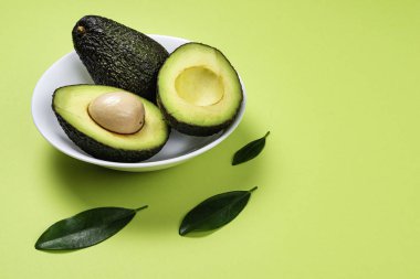 Yeşil arka plan üzerinde seramik tencere içinde Avokado.