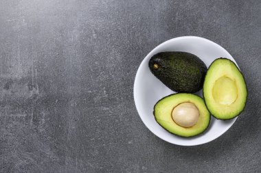 Dokulu gri arka plan üzerinde seramik tencere içinde Avokado.