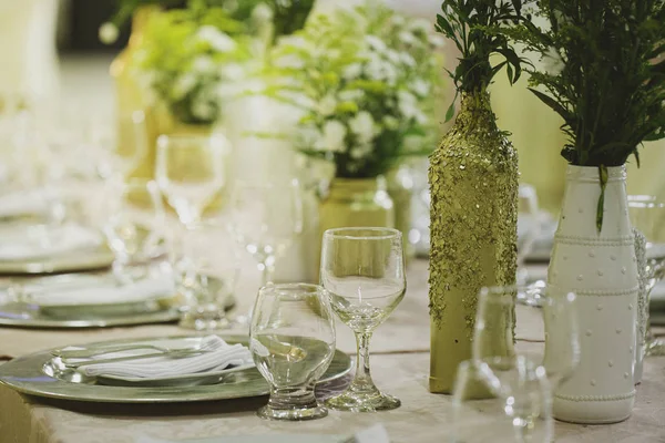 Düğün etkinliği için dekore edilmiş masa. Renkler altın ve beyaz.