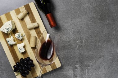Beton arka plan üzerinde şarap ile peynir ve cam çizgili tahta. Kopyalama Alanı.