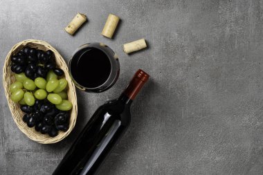 Beton arka plan üzerinde üzüm ve şarap bardağı ile Sepet. Kopyalama Alanı.