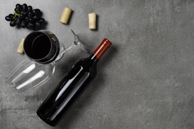 Şarap şişesi, kase, mantar, açacağı ve beton arka plan üzerinde üzüm. Kopyalama Alanı.