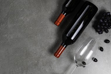 Beton arka planda şarap, cam ve üzüm şişeleri. Kopyalama Alanı.