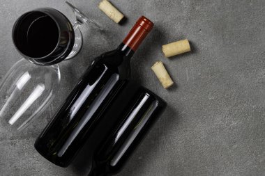 Beton arka planda şarap bardakları ve mantarlar şişesi. Kopyalama Alanı.