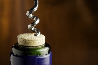 Ahşap arka planda tirbuşonlu bir şişe şarap..