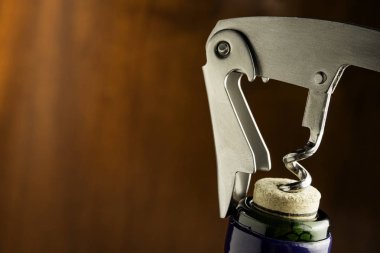 Ahşap arka planda tirbuşonlu bir şişe şarap..