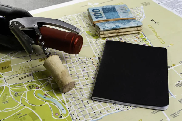 酒瓶和瓶塞在地图上的路线规划 用于笔记的黑色笔记本 — 图库照片