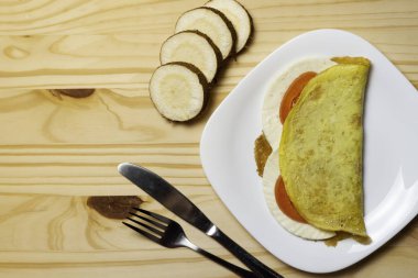 Casabe (bammy, beiju, bob, biju). Manyok gözleme (tapioca) caprese salatası ile (domates, mozzarella) plaka pinus ahşap arka plan üzerinde. Seçici odaklama.