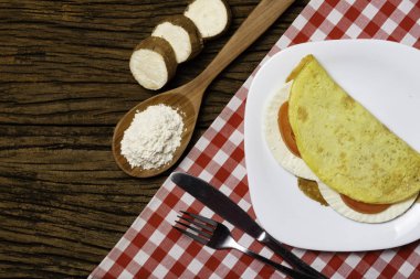 Crepioca. Eski ahşap arka plan üzerinde tabakta peynir ve domates ile manyok (tapyoka) Pancake. Seçici odaklama.