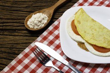 Crepioca. Eski ahşap arka plan üzerinde tabakta peynir ve domates ile manyok (tapyoka) Pancake. Seçici odaklama.