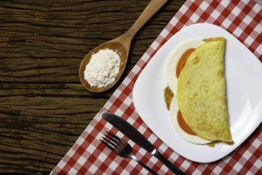 Crepioca. Eski ahşap arka plan üzerinde tabakta peynir ve domates ile manyok (tapyoka) Pancake. Seçici odaklama.