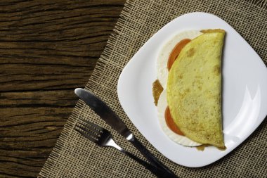 Crepioca. Eski ahşap arka plan üzerinde tabakta peynir ve domates ile manyok (tapyoka) Pancake. Seçici odaklama.