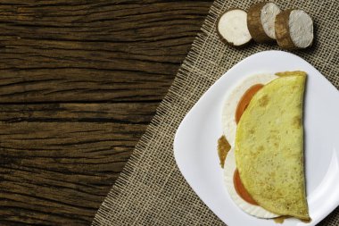 Crepioca. Eski ahşap arka plan üzerinde tabakta peynir ve domates ile manyok (tapyoka) Pancake. Seçici odaklama.
