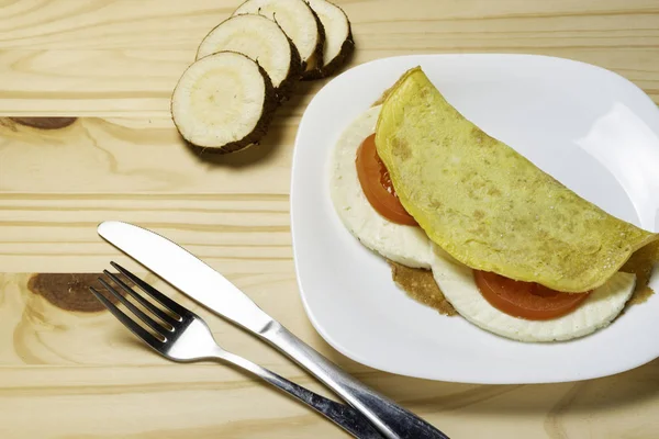 Casabe (bammy, beiju, bob, biju). Manyok gözleme (tapioca) caprese salatası ile (domates, mozzarella) plaka pinus ahşap arka plan üzerinde. Seçici odaklama.