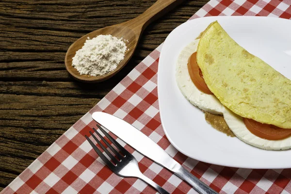 Crepioca. Eski ahşap arka plan üzerinde tabakta peynir ve domates ile manyok (tapyoka) Pancake. Seçici odaklama.
