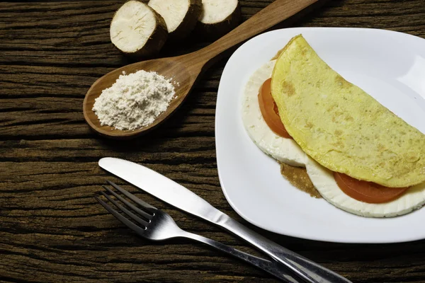 Crepioca. Eski ahşap arka plan üzerinde tabakta peynir ve domates ile manyok (tapyoka) Pancake. Seçici odaklama.