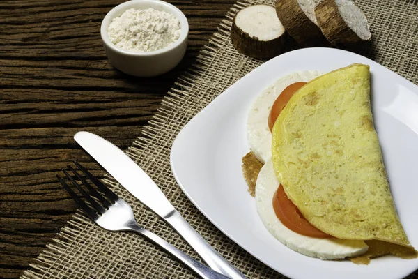 Crepioca. Eski ahşap arka plan üzerinde tabakta peynir ve domates ile manyok (tapyoka) Pancake. Seçici odaklama.