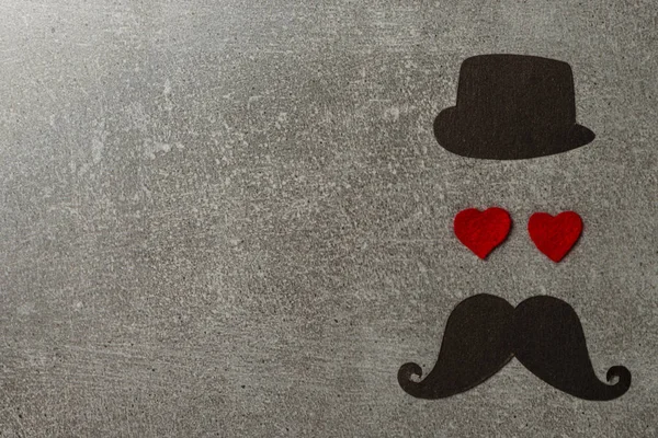Father\'s day background or card. red sign of mustache with two red heart - eyes. empty copy space for inscription. Black hat and mustache.