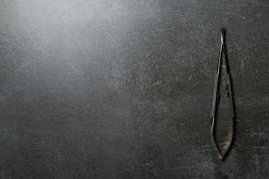 Beton masa üzerinde kavisli iğne tutucu.