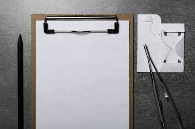 Dikiş ameliyatı için kavisli iğne tutucu. Naylon cerrahi iplik ve not defteri.