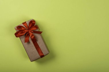 Yeşil neon arka plan üzerinde yay ile Hediye kutusu. Resmin sağ tarafındaki metin için alan.