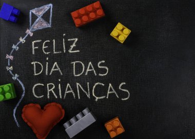 Blackboard Feliz dia das criancas (Portekizce) yazılı. Uçurtma Çizim ve montaj parçaları ve kalp kumaş ile yapılan. Kopyalama alanı.