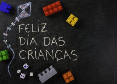Blackboard Feliz dia das criancas (Portekizce) yazılı. Uçurtma Çizim ve parçaları ve oyun zar monte. Kopyalama alanı.