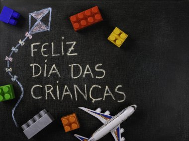 Blackboard Feliz dia das criancas (Portekizce) yazılı. Uçurtma Çizim ve parçaları monte etmek ve oyuncak düzlem. Kopyalama alanı.