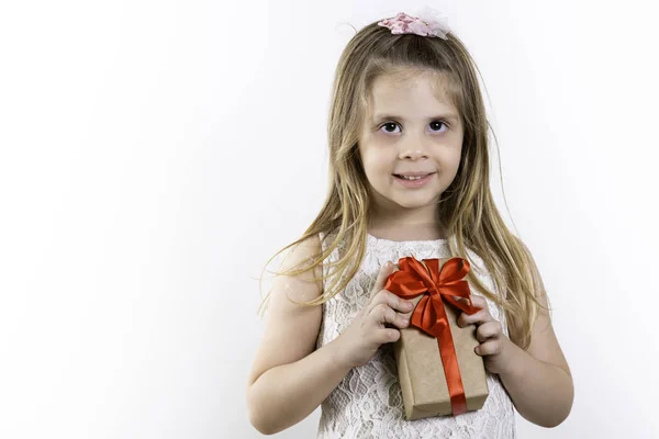 Cute Girl Dziewczyna Trzyma Prezent Czerwoną Kokardą Dzień Dziecka Białe — Zdjęcie stockowe