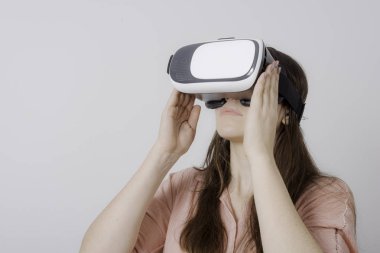 Her iki elinde tutarak ve yukarı bakıyor Vr cihazı nı kullanan kadın.