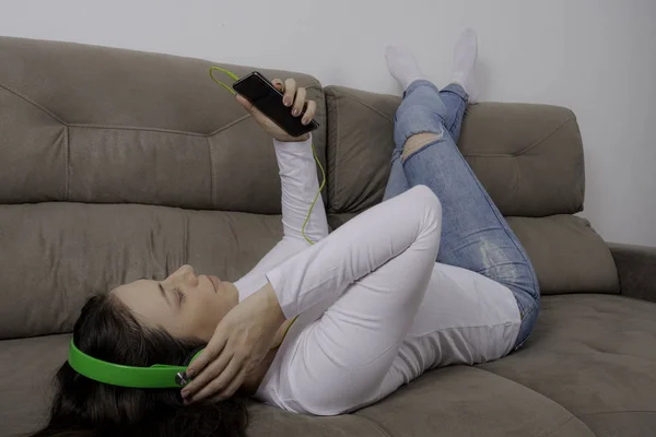 Joven Chica Hermosa Con Auriculares Tumbados Sofá Escuchando Música Relajarse — Foto de Stock